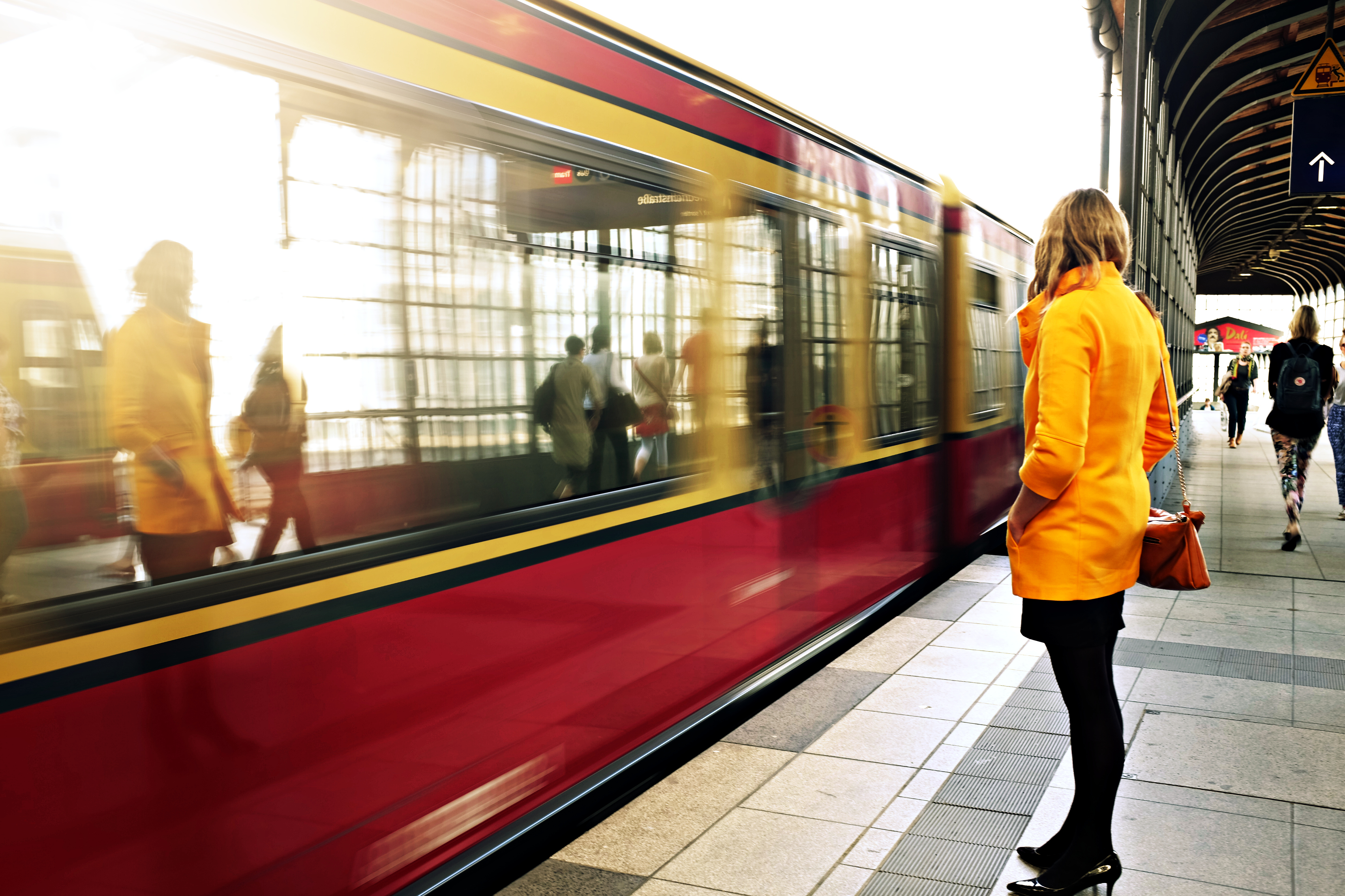 Eine Frau steht am Bahnhof